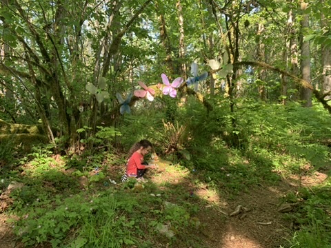 Jody's daughter exploring the Gnome Trail under colorful fairy wings in the trees