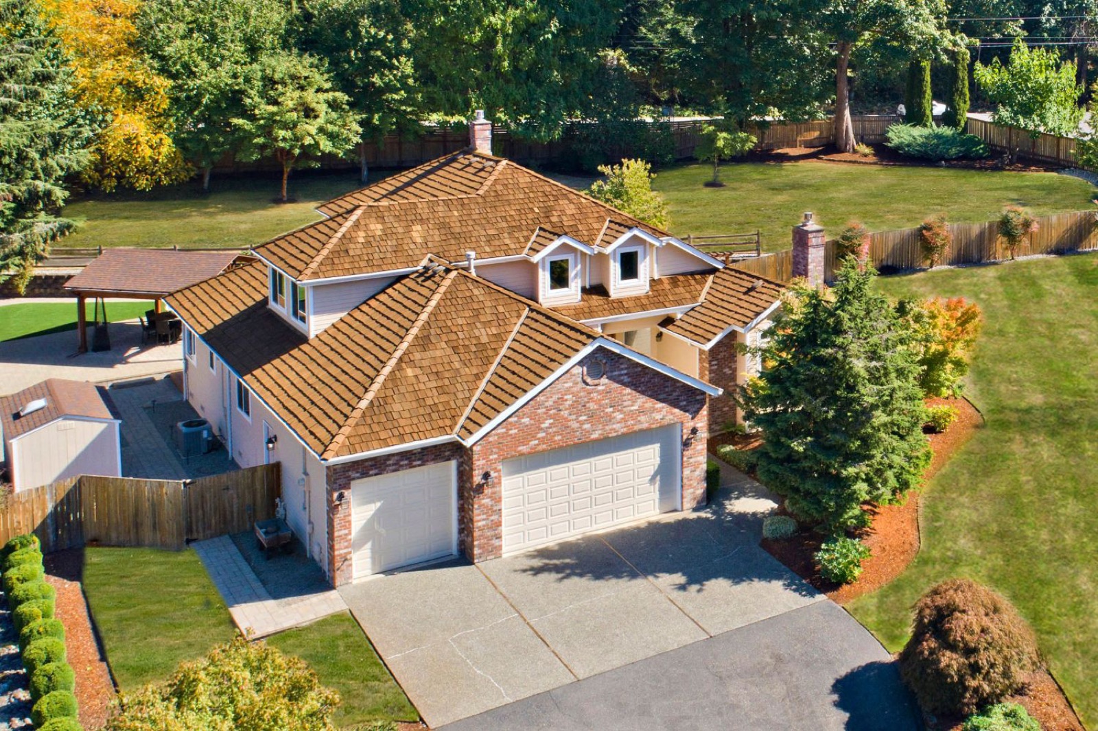 Brick home with a three-car garage and a landscaped yard