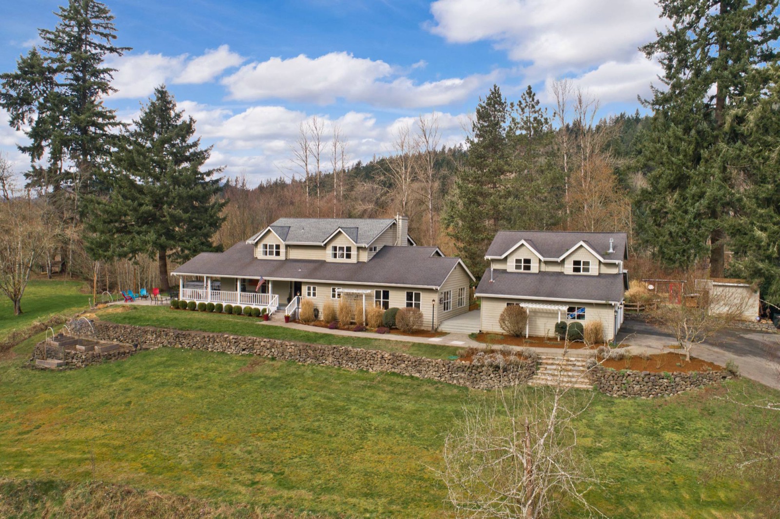 Farmhouse with a covered porch, a second home, and stone garden walls