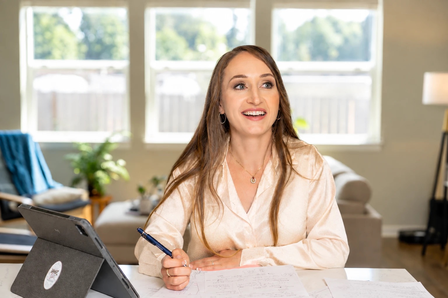 Jody at her desk by a sunny window with notes and a tablet