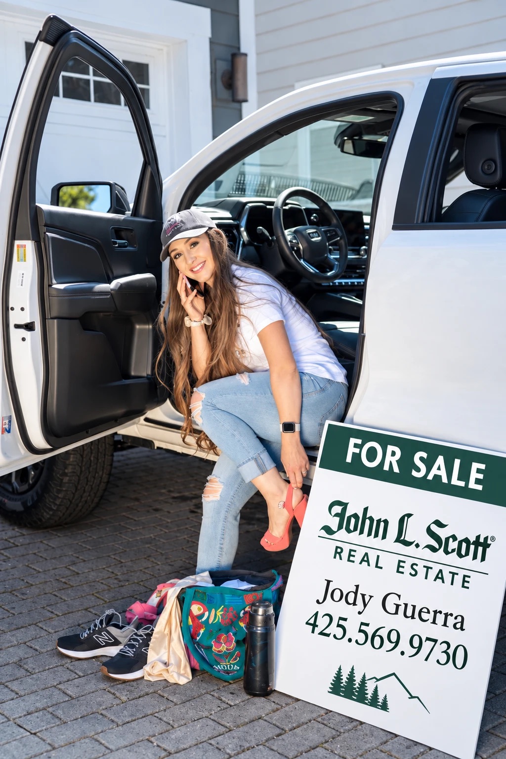 Jody on the phone in her truck beside her John L. Scott For Sale sign