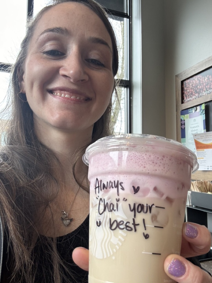 Jody holding an iced chai with Always chai your best written on the cup