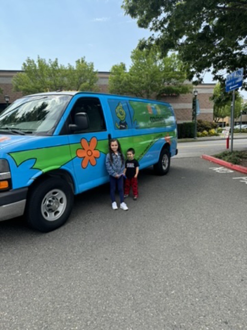 Jody's kids next to a Scooby-Doo style Mystery Machine van at Covington Days