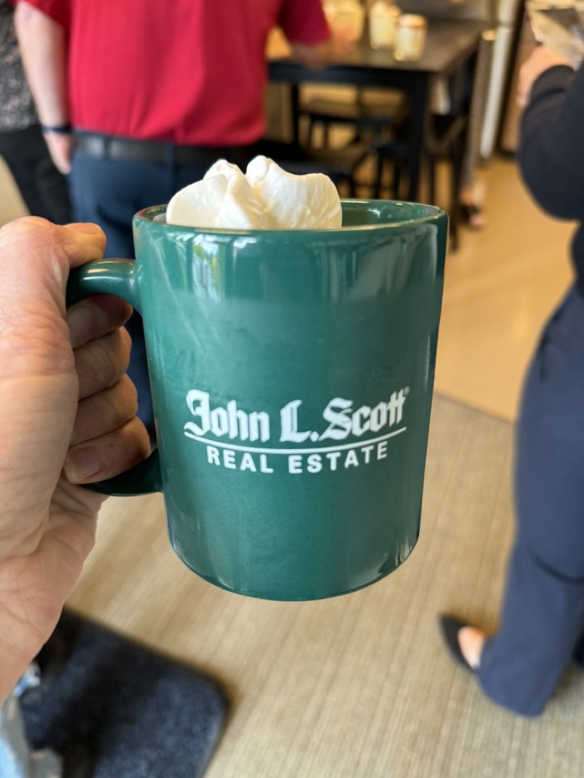 Hot cocoa with whipped cream in a John L. Scott mug