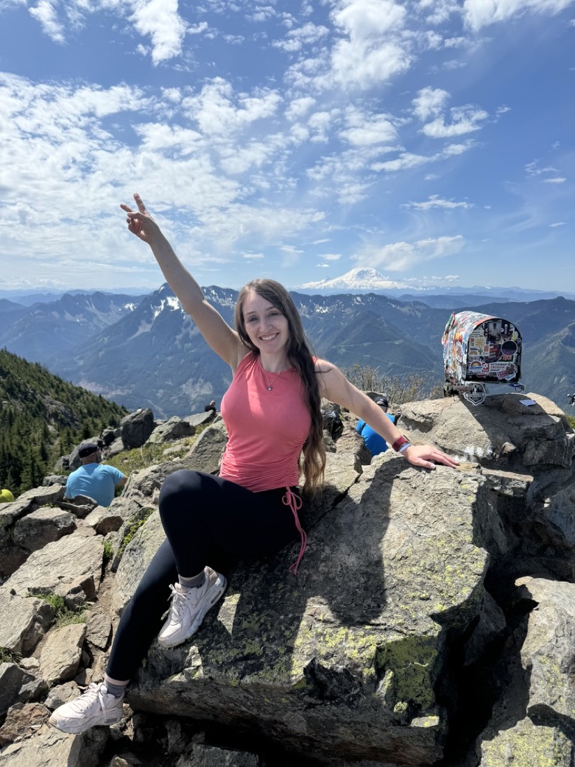 Jody at the Mailbox Peak summit with Mount Rainier behind her