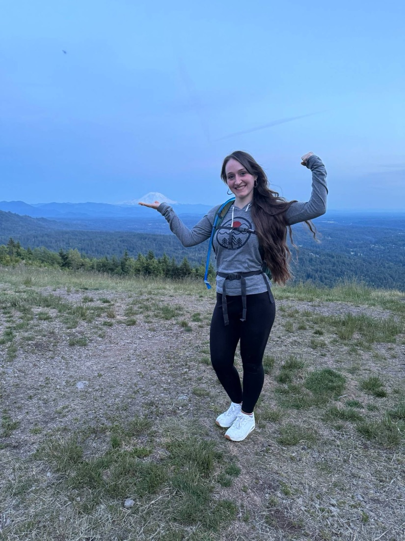 Jody at Poo Poo Point in Issaquah gesturing toward Mount Rainier at dusk